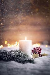festliches Weihnachtsgesteck mit Kerze im Schnee