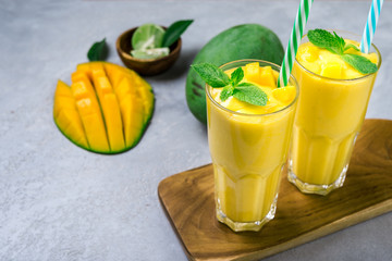 Fresh mango juice and mango fruit on grey background