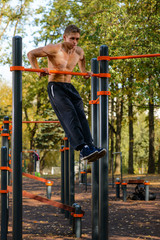 Fototapeta premium Muscular man doing pull-ups on horizontal bar