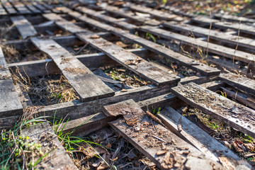 Empty hard wood palettes in very bad condition, abandoned storage, out of business conceptual image.