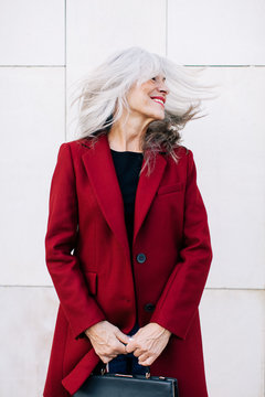 Portrait of a mature woman with grey long hair in movement.