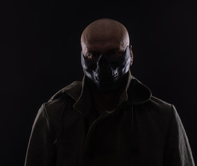 evil man in a scary mask on a black background