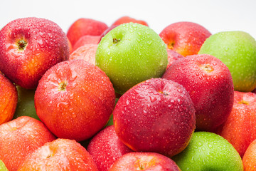 heap of fresh clean green and red apples with drops of water mix on black background, top side view closeup
