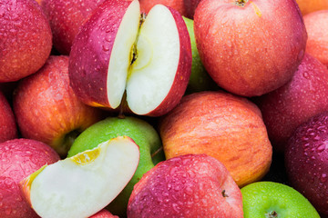 Cut and whole fresh ripe red and green mix apples heap closeup side view