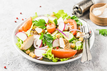 Grilled chicken tomato chickpeas salad with olive oil mustard vinaigrette. Selective focus, space for text.