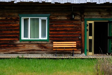 Fototapeta na wymiar Bench in front of log home decorative style hostel