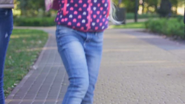 Happy girl walking with parents after school, boasting of interesting classes