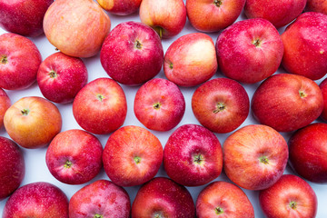 heap of unwashed unclean red apples mix on wooden background, top side view closeup