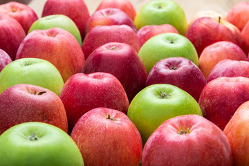 heap of unwashed unclean green and red apples mix on wooden background, top side view closeup