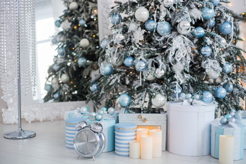 Christmas presents in a different boxes under the Christmas tree in the room or studio