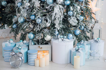 Christmas presents in a different boxes under the Christmas tree in the room or studio