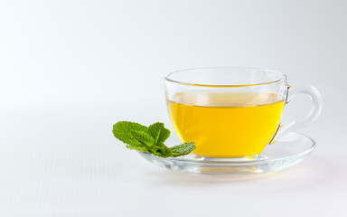 A cup of green tea with mint leaves