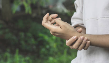 Close up Asian women painful hand in the garden.Concept Help care