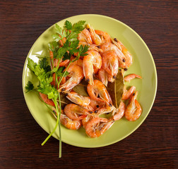 Shrimp and parsley on a green plate. The view from the top.