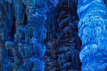 St Michael's limestone cave in Gibraltar. Closeup view of lighted up stalactites and stalagmites formed by accumulation of rock sediments.