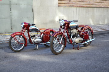 Red vintage motorcycles Jawa 125 and Jawa 500 produced in former Czechoslovakia stand on road - obrazy, fototapety, plakaty