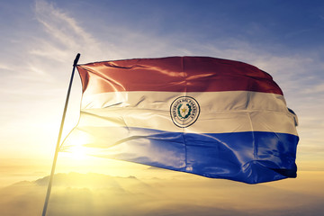 Paraguay Paraguayan flag textile cloth fabric waving on the top sunrise mist fog