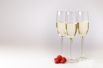 Stylish flutes of champagne with raspberries