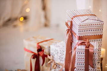 Christmas 2019 - a group of gifts on the background of garlands.  
round gift boxes in pink and purple tones on the background of the garlands and window. With place for text.