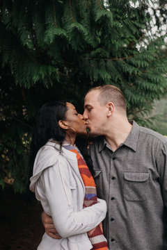 Engaged Couple Kissing in Forest