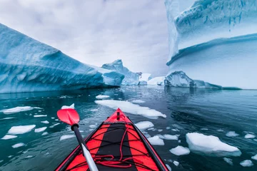 Fototapeten Kajakfahren in der Antarktis zwischen Eisbergen mit aufblasbarem Kajak, extremes Abenteuer auf der antarktischen Halbinsel, wunderschöne unberührte Landschaft, Meerwasserpaddelaktivität © NicoElNino
