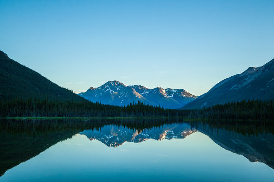 Sunset reflection of mountains on still lake