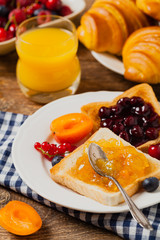 Breakfast. Toasts with cherry or peach jam and fresh fruit.