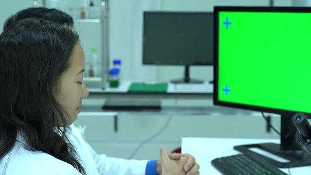 Scientist male talking about working in modern laboratory or medical center. Background monitor green screen. Concept of science, testing development and lab industry.