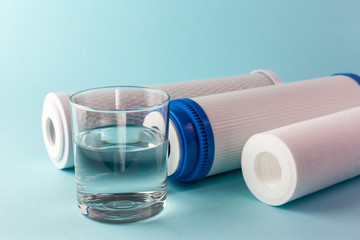 A glass of water on the background of filter cartridges