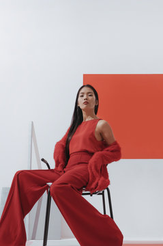 Asian fashionable female model with long hair in red in abstract space ./Fashion series