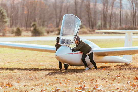Friends pulling glider from the runway after flight