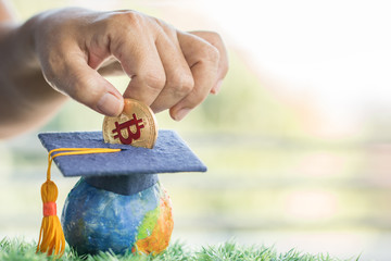 Student hand dropping investing bitcoin money coin to Graduation fund for save moneys in studying...