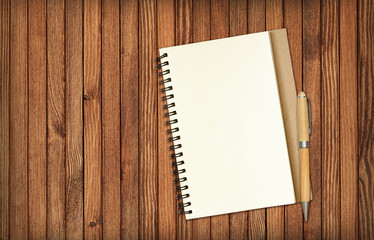 Notepad and a pencil on brown wood