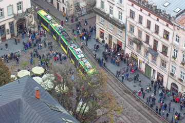 View of the Market Square in Lviv from the height of the city hall tower. People on the street of a European city, top view_