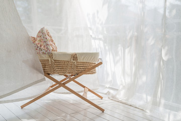 Retro crib stand at balcony in white curtains