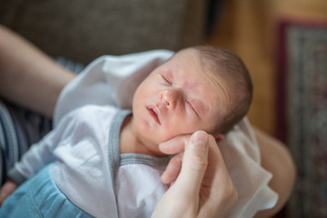 Loving mother hand holding cute sleeping newborn baby child