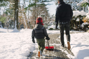 Little kid shoveling snow with dad