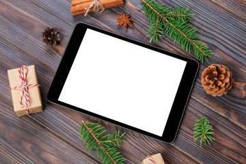 Digital tablet mock up with rustic Christmas wooden background decorations for app presentation. top view with copy space