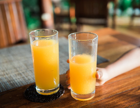 two glasses of fresh orange juice, one half finished