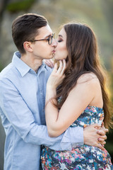 Romantic summer love story on a sunset in mountains. Young girl and boy in love. pregnant women