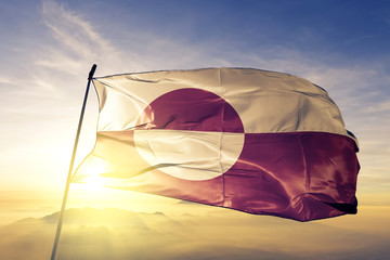 Greenland Denmark Greenlander flag textile cloth fabric waving on the top sunrise mist fog