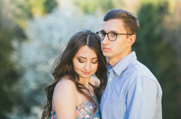 Obraz premium Romantic summer love story on a sunset in mountains. Young girl and boy in love. pregnant women