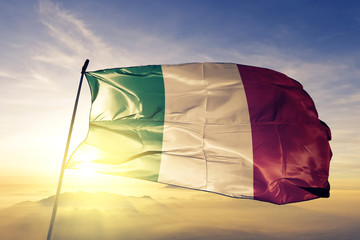 Italy Italian flag textile cloth fabric waving on the top sunrise mist fog