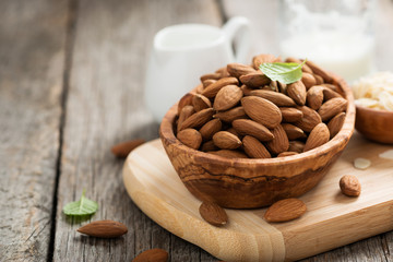 Almonds nuts in wooden bowl on rustic table.