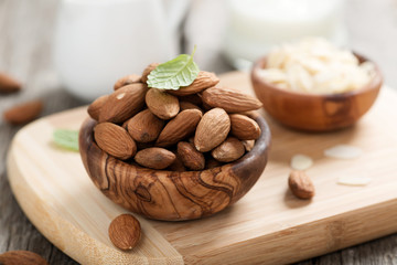 Almonds nuts in wooden bowl on rustic table.