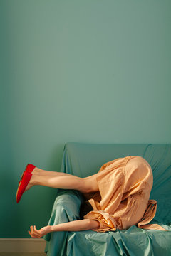 Side view of woman bending on couch
