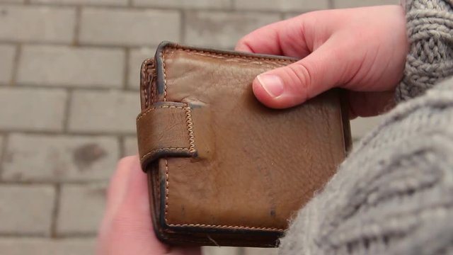 Closeup top view of old brown leather male wallet and kid closes it. Real time full hd video footage.