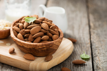 Almonds nuts in wooden bowl on rustic table.