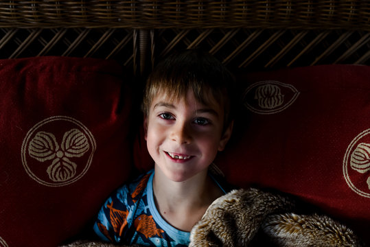 little boy with warm blanket and toothless grin