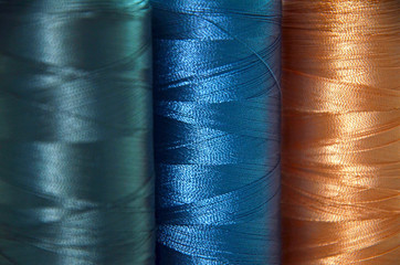 threads in blue colors on the background of a sewing machine